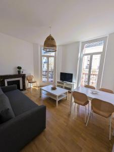 ein Wohnzimmer mit einem Sofa und einem Tisch in der Unterkunft 102 - Appart rénové avec grand salon et 1 chambre - Tram et Clinique Mutualiste à 1 min in Grenoble