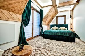 a bedroom with a green bed and a large window at Domki pod Grapą JAKUZZI & DELUXE & Willa pod Grapą in Poronin