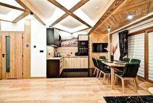 a kitchen and dining room with a table and chairs at Domki pod Grapą JAKUZZI & DELUXE & Willa pod Grapą in Poronin