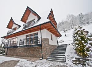 a house with snow on the ground at Domki pod Grapą JAKUZZI & DELUXE & Willa pod Grapą in Poronin