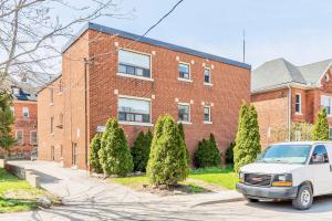 een wit busje geparkeerd voor een bakstenen gebouw bij Corktown Hamilton - Modern Apartment in Hamilton