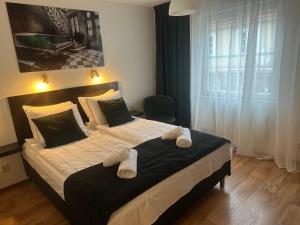 - une chambre avec un grand lit et des serviettes dans l'établissement Hotell City Karlshamn, à Karlshamn