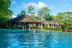 uma villa com piscina em frente a uma casa em Sheridan Boutique Resort Iloilo em Iloilo