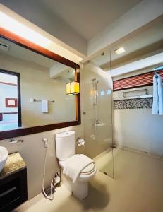 uma casa de banho com um WC e uma cabina de duche em vidro. em Sheridan Boutique Resort Iloilo em Iloilo