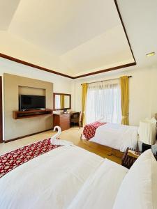 um quarto de hotel com duas camas e uma televisão em Sheridan Boutique Resort Iloilo em Iloilo