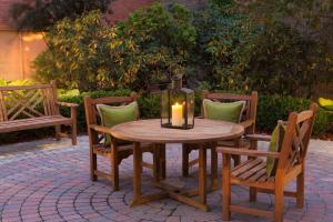 einen Holztisch und Stühle mit Kerzen auf der Terrasse in der Unterkunft Hyatt Regency Boston/Cambridge in Cambridge