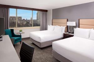 ein Hotelzimmer mit 2 Betten und einem Stuhl in der Unterkunft Hyatt Regency Boston/Cambridge in Cambridge