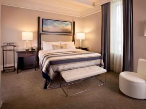 a hotel room with a bed and a chair at Fairmont Palliser in Calgary