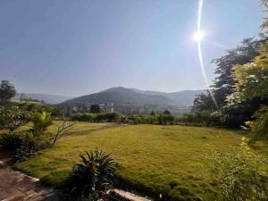 un grand champ d'herbe avec le soleil dans le ciel dans l'établissement Endora homestay - A fully equipped lake-facing 3BHK, à Lavasa