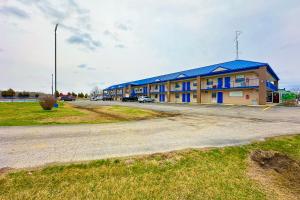 um edifício com um telhado azul e um parque de estacionamento em Happy Stay Inn Madisonville I-69 By OYO em Madisonville