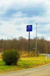 um sinal azul no lado de uma estrada em Happy Stay Inn Madisonville I-69 By OYO em Madisonville