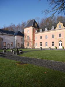 a large building with benches in front of it at Château du Pont d'Oye in Habay-la-Neuve