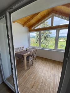 uma sala de jantar com uma mesa e uma grande janela em Apartmán Nikol em Prievidza