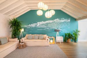 - un salon avec un canapé et un mur bleu dans l'établissement Praia FLH Hotels Ericeira, à Ericeira