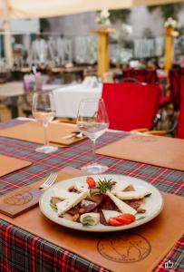 une assiette de nourriture sur une table avec deux verres à vin dans l'établissement Little Bay Apartments, à Kotor