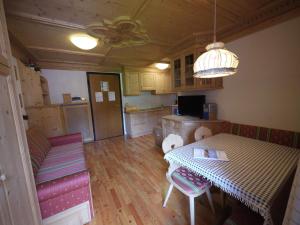 a living room with a table and a kitchen at Appartamento Brentegani in Arabba