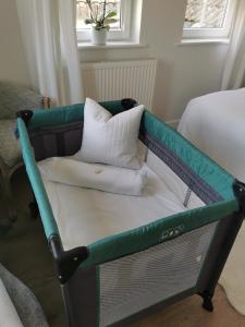 een bed met groene en witte kussens erop bij Seashell luxury apartment in Burnham on Sea