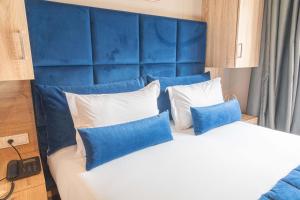 een slaapkamer met een blauw hoofdeinde en een bed met kussens bij Rent-inn Boutique Hotel in Rabat