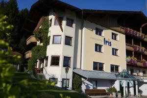 un gran edificio blanco con hiedra. en Ferienhotel Iris, en Auffach