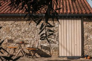 un edificio con puerta, mesa y sillas en Casinhas da Póvoa- Turismo Natureza, en Castelo de Vide