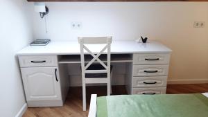 a white desk with a chair in a room at Апартаменти - Історія з вікна in Kamianets-Podilskyi