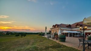 um edifício com uma mesa e cadeiras e um pôr-do-sol em St Peter Vini em Svätý Peter