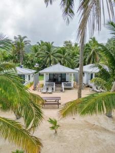 un edificio sulla spiaggia con panchina e palme di Bella Beach Bungalows a Rarotonga