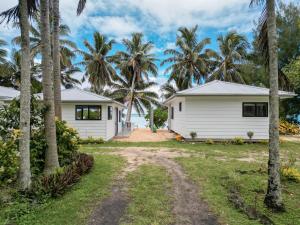 una casa con palme di fronte di Bella Beach Bungalows a Rarotonga