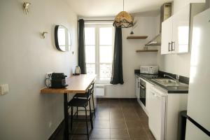 una pequeña cocina con encimera y mesa en La Cour Des Senteurs / F2 Château de Versailles, en Versalles