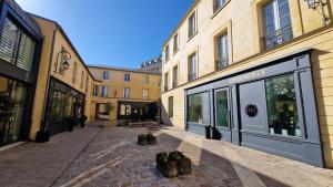 una calle vacía en una ciudad con edificios en La Cour Des Senteurs / F2 Château de Versailles, en Versalles