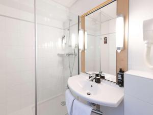 y baño blanco con lavabo y ducha. en ibis Paris Grands Boulevards Opéra 9e, en París