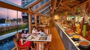 un groupe de personnes assises à table dans un restaurant dans l'établissement O by Tamara, Trivandrum, à Trivandrum