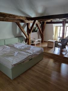 una camera con un letto in una stanza con pavimenti in legno di Hotel Celerin a Telč