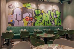 un restaurante con mesas y una pared con graffiti en Pestana Lisboa Vintage City Center Suites, en Lisboa