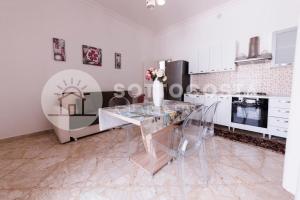 comedor con mesa de cristal en la cocina en Floral Flat - Porto Cesareo, en Porto Cesareo