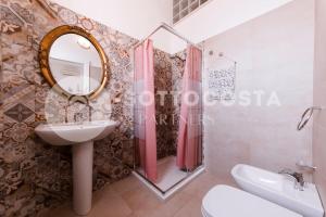 y baño con lavabo y espejo. en Floral Flat - Porto Cesareo, en Porto Cesareo