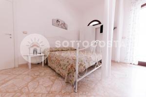 Dormitorio blanco con cama y mesa en Floral Flat - Porto Cesareo, en Porto Cesareo