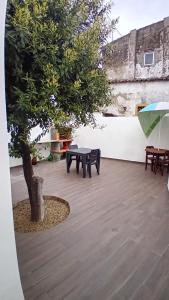 a patio with benches and a tree and an umbrella at Apartment in Semeador in Portalegre