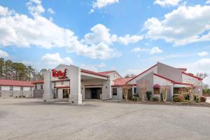 un bâtiment avec un panneau king-size hamburger dans un parking dans l'établissement Red Roof Inn & Suites Newport News, à Newport News