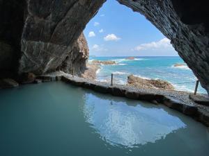 una cueva con una piscina de agua frente al océano en Hotel Urashima, en Katsuura