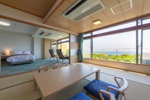 Habitación con cama, mesa y sillas. en Hotel Urashima, en Katsuura