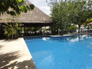 einen großen blauen Pool mit Strohdach in der Unterkunft Sotavento Hotel & Yacht Club in Cancún