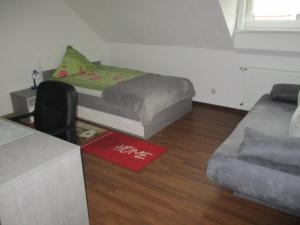 ein kleines Zimmer mit einem Bett und einem Sofa in der Unterkunft Ferienwohnung Thüringer Wald in Ilmenau