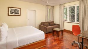 a bedroom with a bed and a chair and a desk at Fairview Hotel Nairobi in Nairobi