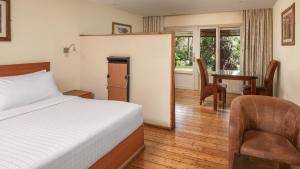 a bedroom with a bed and a table and a chair at Fairview Hotel Nairobi in Nairobi