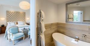 a bathroom with a bed and a tub and a bedroom at Lindeth Fell Country House in Bowness-on-Windermere