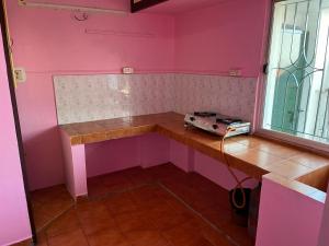 een kamer met roze muren, een tafel en een raam bij Valley Villa 2BHK in Kodaikānāl