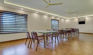 - une salle à manger avec des tables, des chaises et des fenêtres dans l'établissement Treebo Golden Terminal, Kochi Airport, à Cochin