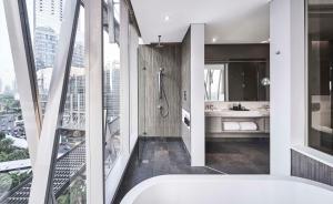 ein Badezimmer mit Badewanne und Stadtblick in der Unterkunft Alila SCBD Jakarta in Jakarta