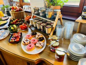 einen Tisch mit Teller mit Donuts und anderen Lebensmitteln in der Unterkunft Hotel Siebeneichen  in Meißen